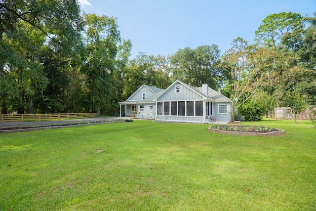 back of property with a sunroom and a yard