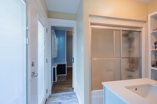 bathroom with shower / bath combination with glass door, vanity, and wood-type flooring