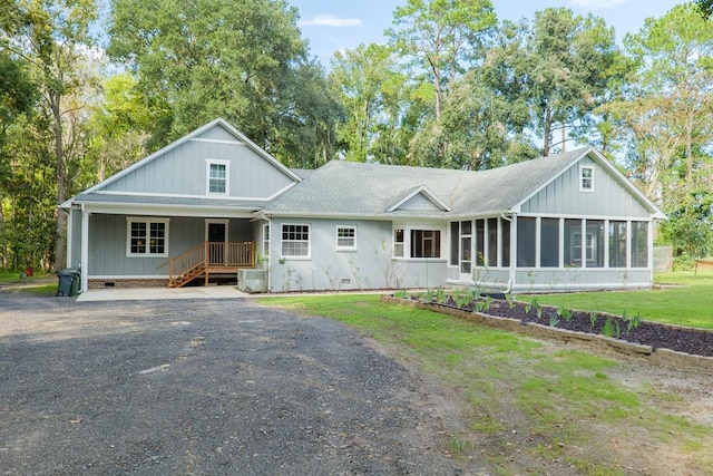 view of front facade with a sunroom and a front lawn