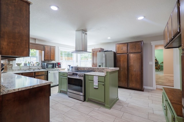 kitchen featuring appliances with stainless steel finishes, a textured ceiling, island range hood, sink, and green cabinetry