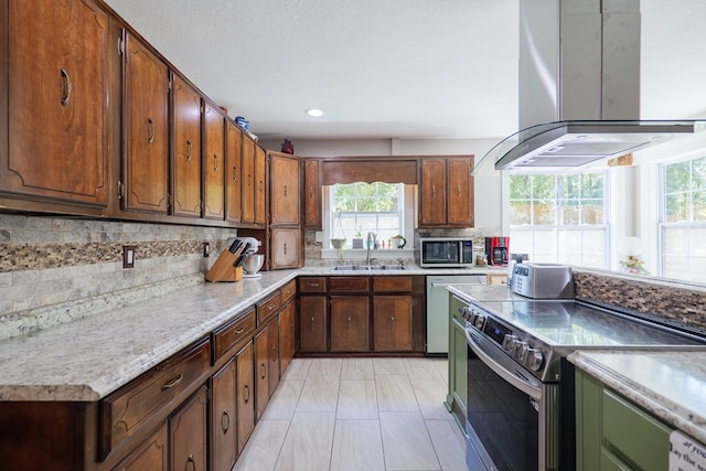 kitchen featuring island exhaust hood, appliances with stainless steel finishes, plenty of natural light, and sink