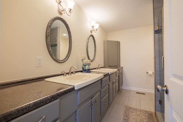 bathroom featuring tile patterned flooring, vanity, and a textured ceiling