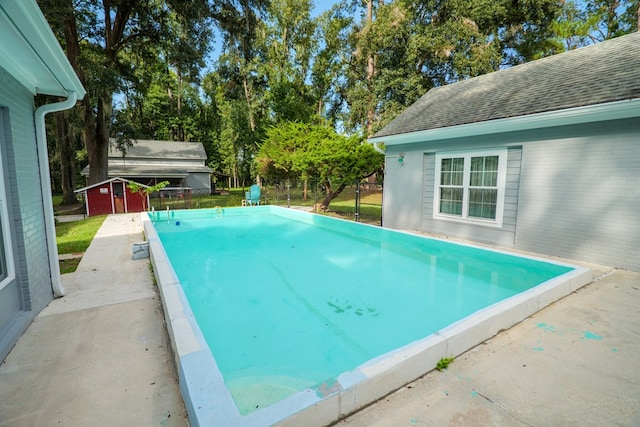 view of swimming pool featuring a shed