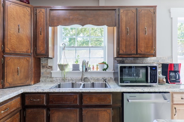 kitchen with backsplash, sink, and stainless steel appliances