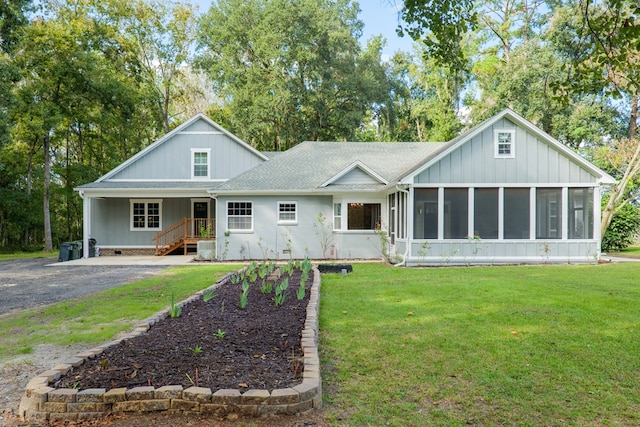 view of front of house with a sunroom and a front lawn