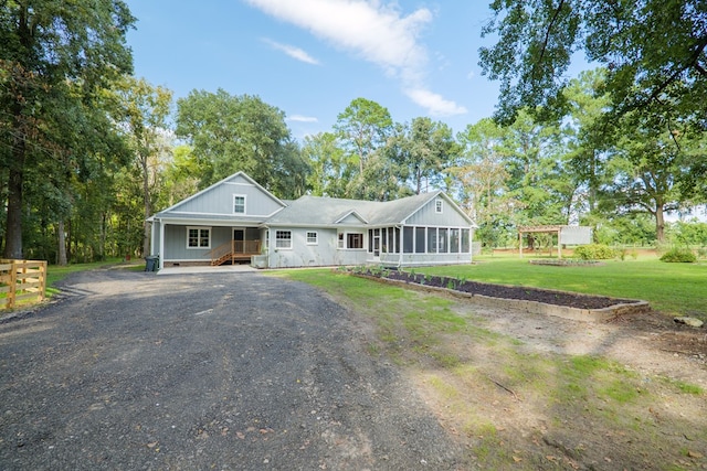 ranch-style home with a sunroom and a front lawn