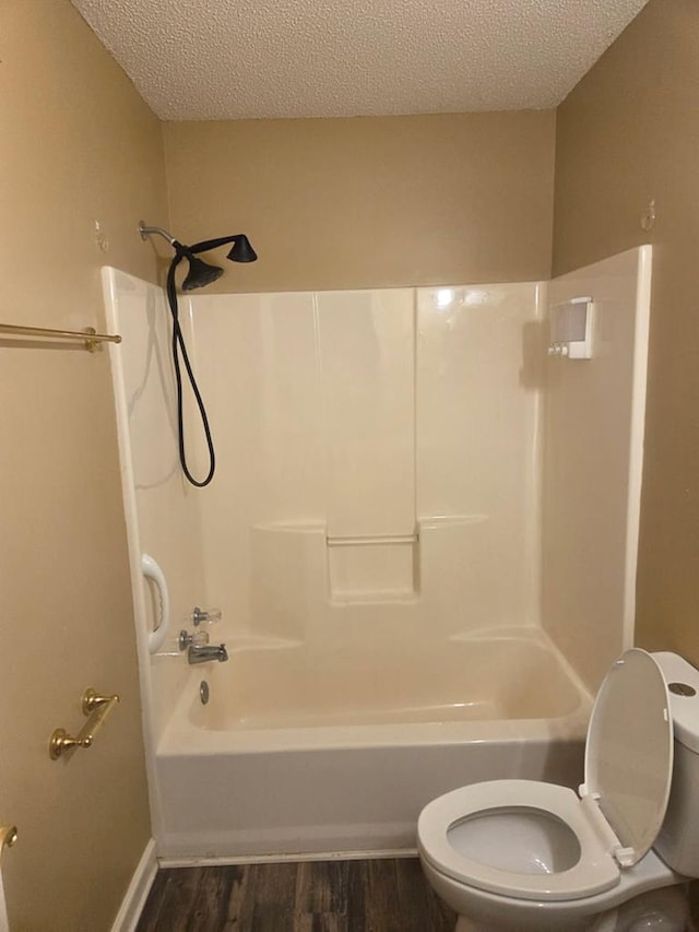 717 E 44th St, Tifton, GA 37194 - bathroom featuring toilet, a textured ceiling, wood finished floors, and tub / shower combination