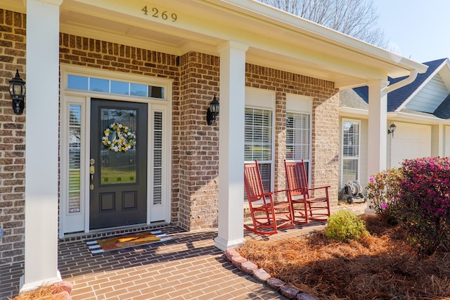 property entrance featuring brick siding and covered porch