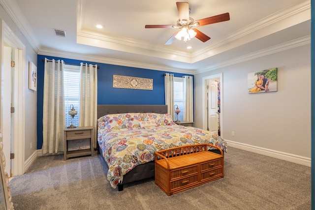 carpeted bedroom with visible vents, baseboards, a tray ceiling, and ornamental molding