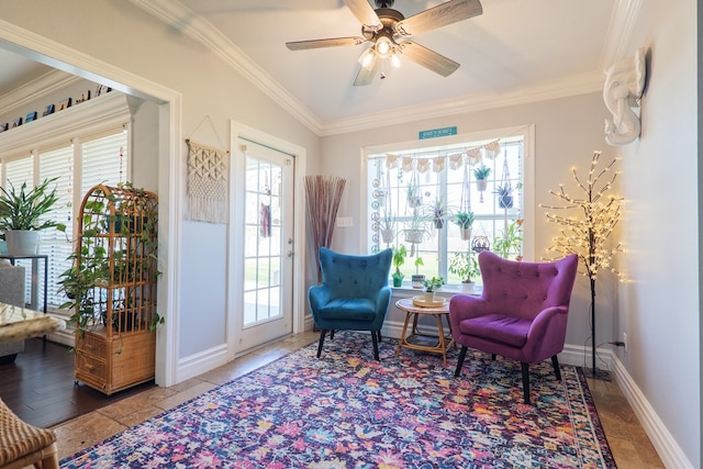 living area featuring baseboards, a healthy amount of sunlight, ceiling fan, and crown molding