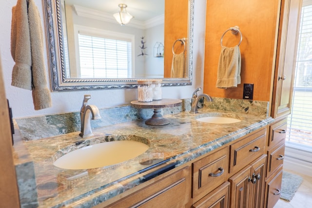 bathroom with crown molding, double vanity, and a sink