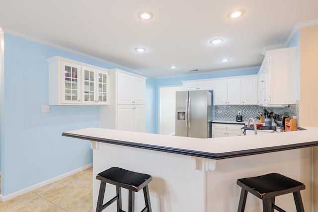 4600 Rustic Ridge Rd, Valdosta, GA 31602 - kitchen with stainless steel refrigerator with ice dispenser, a peninsula, a breakfast bar, tasteful backsplash, and recessed lighting
