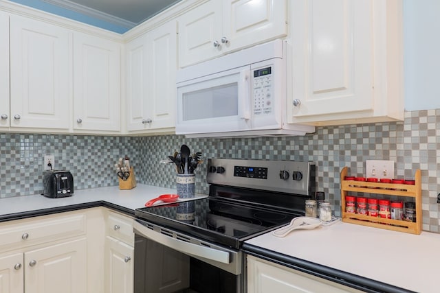 4600 Rustic Ridge Rd, Valdosta, GA 31602 - kitchen featuring stainless steel range with electric stovetop, white microwave, white cabinets, tasteful backsplash, and light countertops