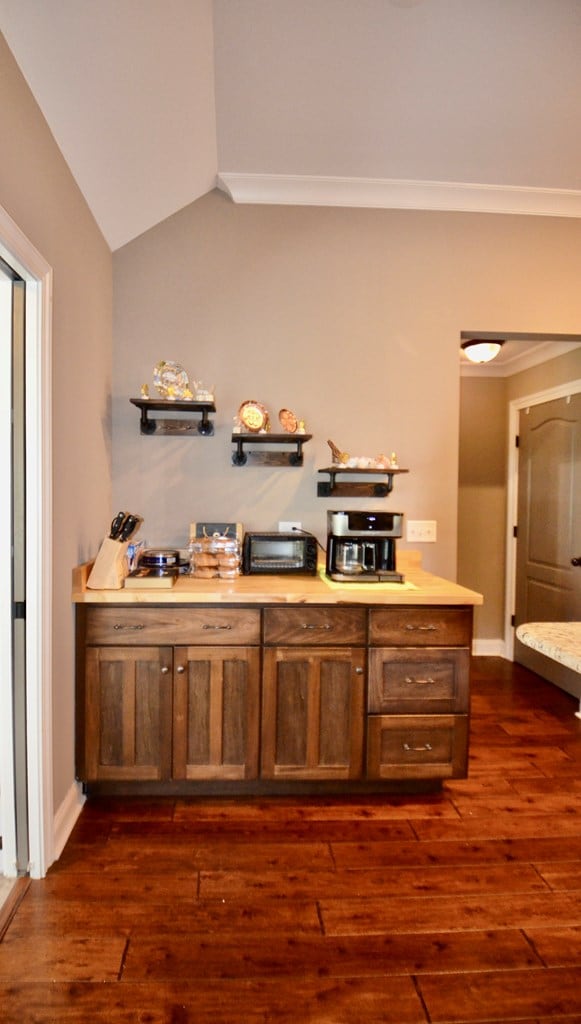 bar with crown molding, dark hardwood / wood-style flooring, and vaulted ceiling