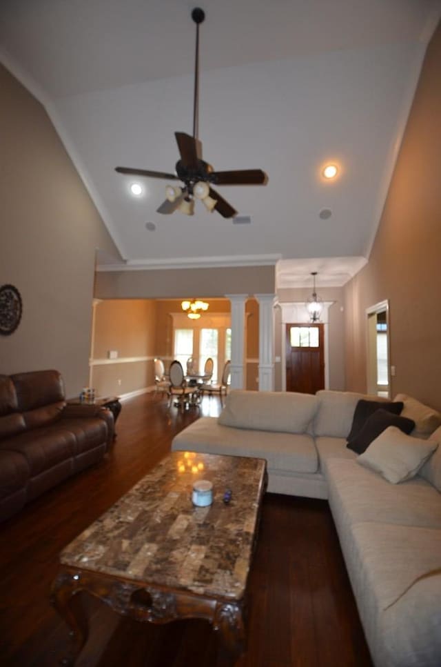 living room featuring decorative columns, crown molding, dark wood-type flooring, and ceiling fan with notable chandelier