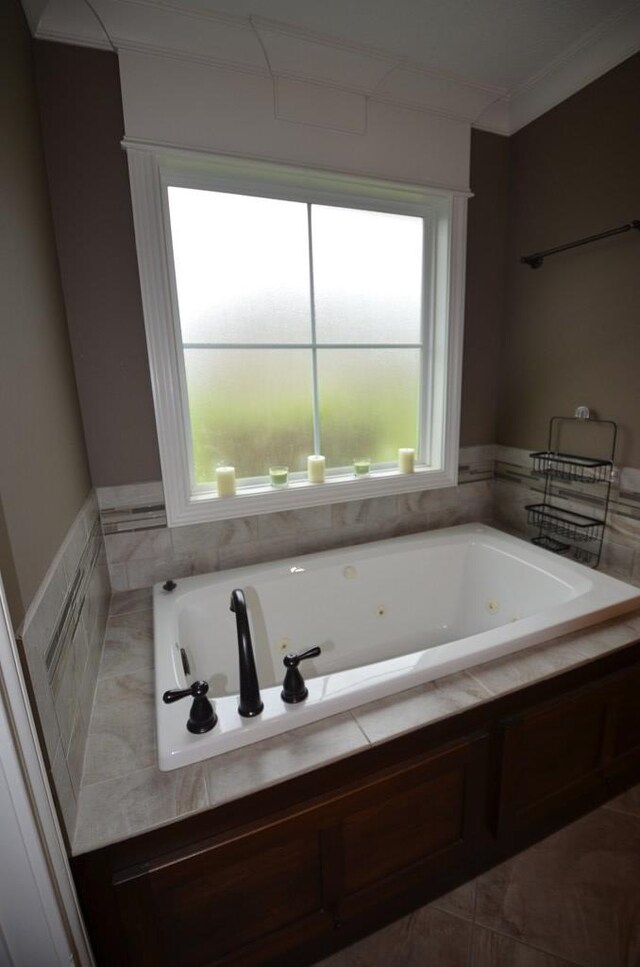 bathroom featuring tiled bath, tile patterned floors, a wealth of natural light, and ornamental molding