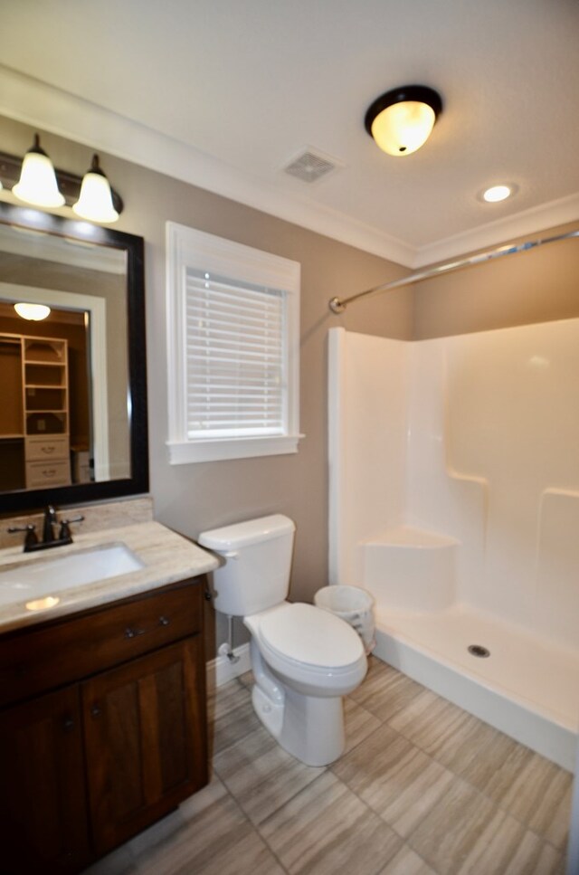 bathroom featuring a shower, vanity, and toilet