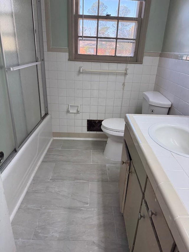 full bathroom with vanity, toilet, and bath / shower combo with glass door