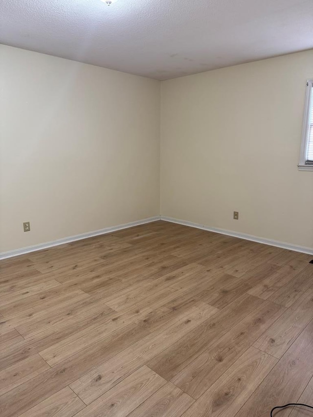 empty room featuring light wood-style flooring and baseboards