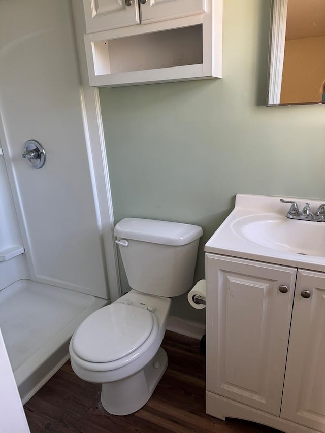 full bathroom with toilet, walk in shower, wood finished floors, and vanity