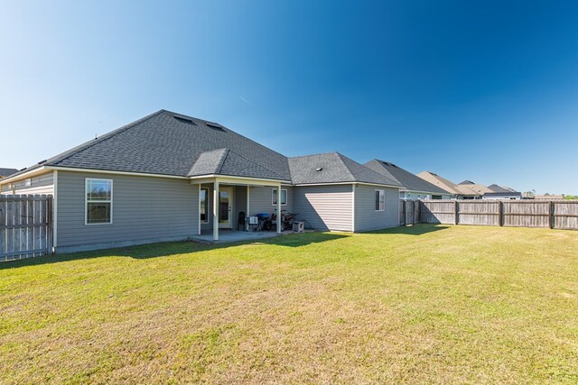 3908 Crusader Ct, Valdosta, GA 31605 - rear view of property with a patio, a fenced backyard, a lawn, and roof with shingles