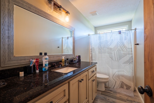 3908 Crusader Ct, Valdosta, GA 31605 - full bathroom with a textured ceiling, toilet, wood finished floors, vanity, and a shower with curtain