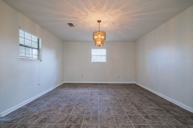 spare room featuring a notable chandelier