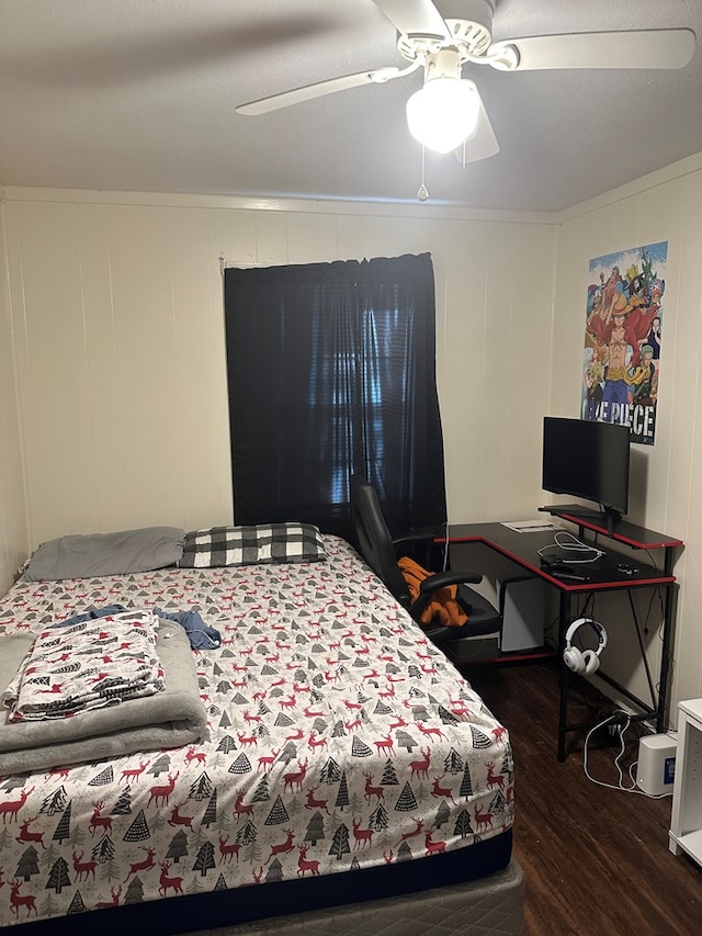 bedroom featuring crown molding, dark wood-style flooring, and ceiling fan