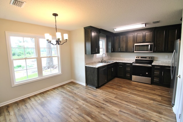 kitchen featuring visible vents, light wood-type flooring, appliances with stainless steel finishes, and a chandelier