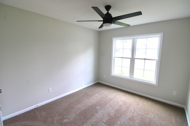 spare room featuring a textured ceiling, carpet flooring, baseboards, and a ceiling fan