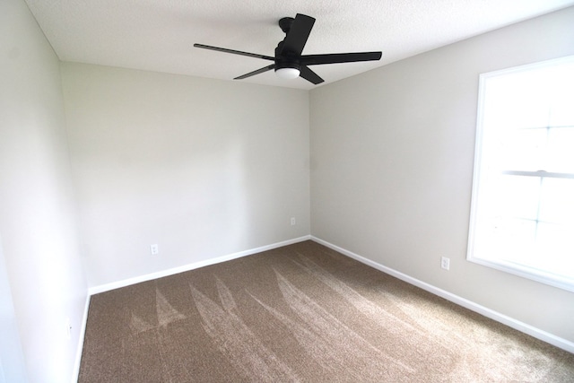 unfurnished room featuring dark carpet, baseboards, and a ceiling fan