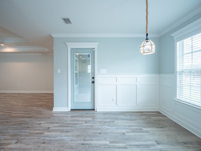 unfurnished room with crown molding, visible vents, plenty of natural light, and light wood finished floors