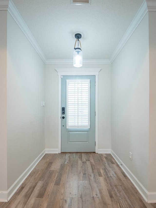 doorway with baseboards, ornamental molding, and wood finished floors