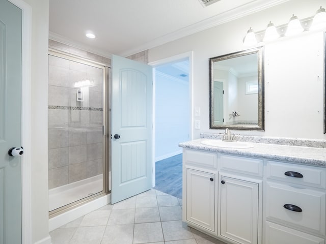 bathroom with ornamental molding, a stall shower, tile patterned flooring, and vanity