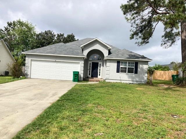 ranch-style home with driveway, fence, a front lawn, a garage, and central AC