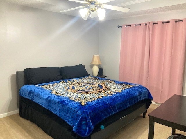 bedroom with light colored carpet, ceiling fan, and baseboards