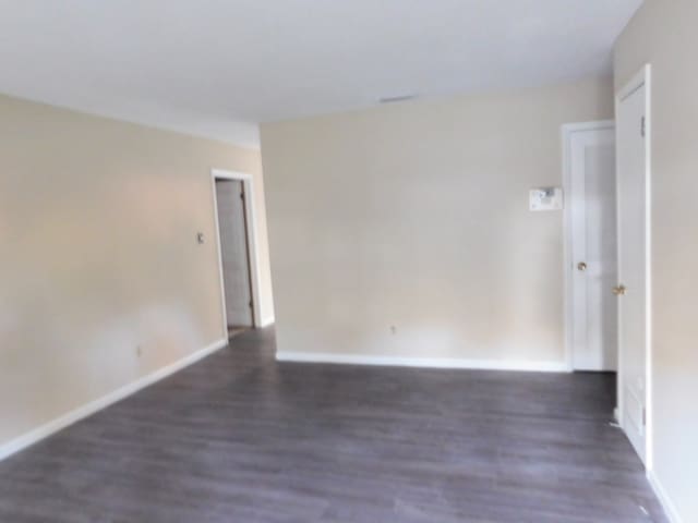 empty room featuring baseboards and wood finished floors