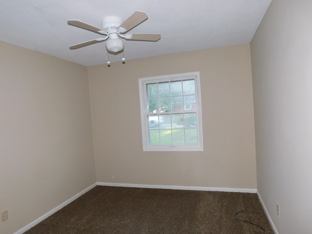 carpeted empty room with a ceiling fan and baseboards