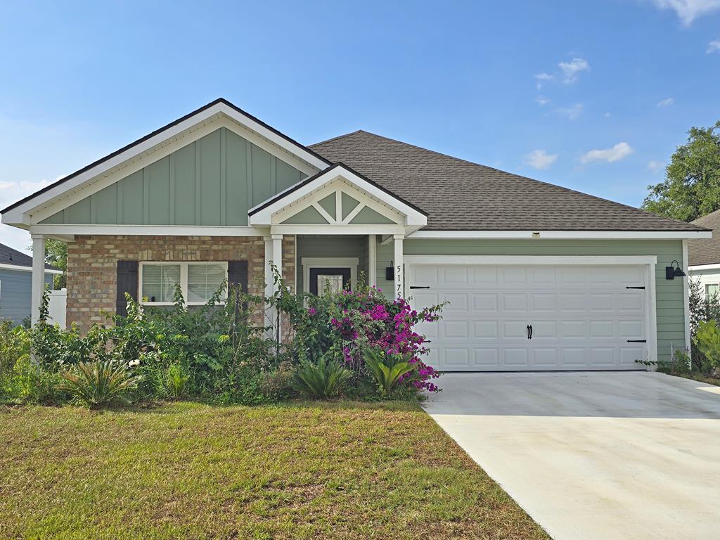 5175 Grand Oak Cir, Lake Park, GA 31636 - view of front of house with board and batten siding, concrete driveway, a front yard, a garage, and roof with shingles