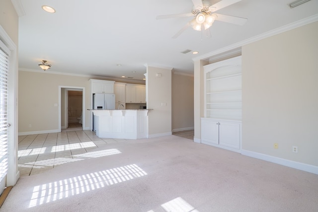 unfurnished living room with ceiling fan, built in features, crown molding, and light carpet