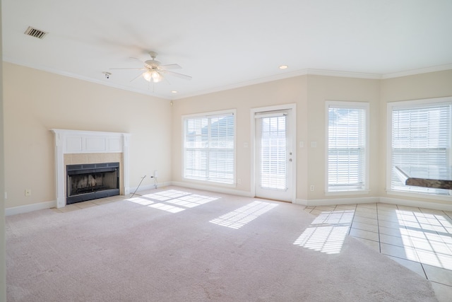 unfurnished living room featuring ceiling fan, a fireplace, light carpet, and ornamental molding