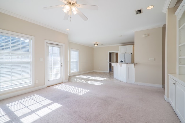 unfurnished living room with light carpet, ceiling fan, and ornamental molding