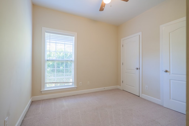 spare room with light colored carpet and ceiling fan