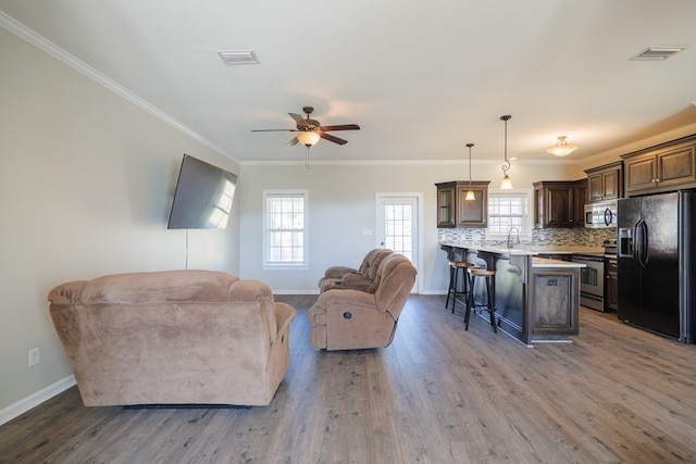 living room featuring crown molding, ceiling fan, dark wood-type flooring, and sink