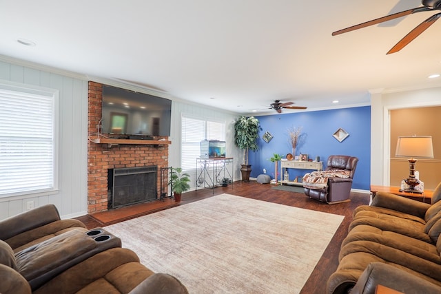 living room featuring ornamental molding, ceiling fan, wood finished floors, and a fireplace