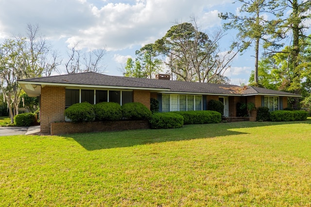 single story home with brick siding, a chimney, and a front lawn