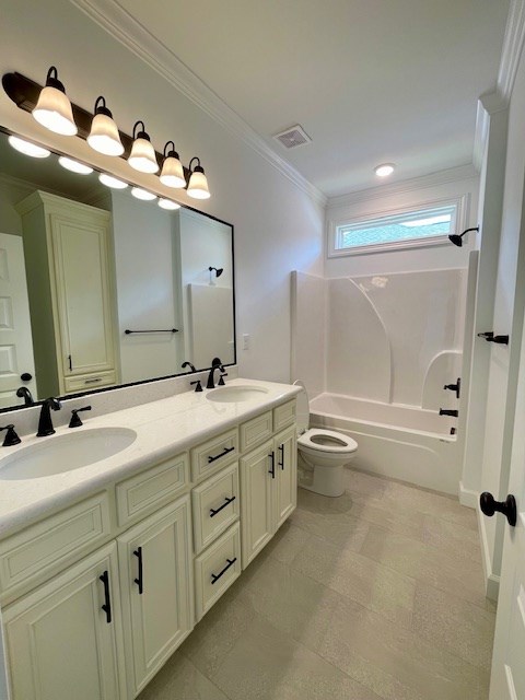 full bath with double vanity, a sink, visible vents, and crown molding