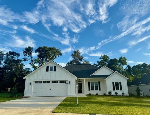 view of front facade with board and batten siding, a front yard, driveway, and a garage