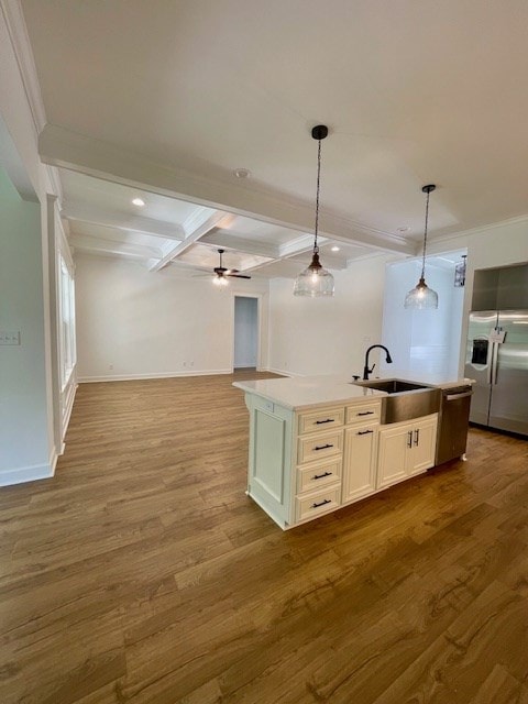 kitchen with stainless steel fridge, open floor plan, a sink, and wood finished floors