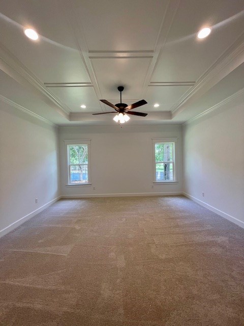 empty room with baseboards, coffered ceiling, carpet, crown molding, and recessed lighting